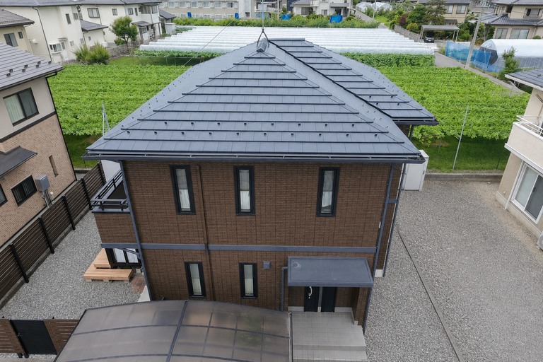 <p>施工後は外壁・屋根ともに深みのある美しい仕上がりとなり、住まい全体が高級感のある外観へと生まれ変わりました。<br>

外壁はマイルドシーラーEPOで下塗りを行い、SKプレミアム無機マイルドで仕上げることで、優れた耐候性・低汚染性・防水性能を実現。屋根もSKプレミアム無機ルーフで仕上げ、長期間にわたり美観を維持できる仕様となっています。<br>

さらに、軒天・雨樋・水切りなどの付帯部塗装に加え、劣化していた胴差しをGL鋼板へ交換し、室外機カバーも新しく交換。塗装と修繕工事を組み合わせることで、建物全体の耐久性・機能性・美観を大きく向上させました。<br>

使用材料・施工内容<br>

外壁塗装工事<br>

・高圧洗浄<br>
・下塗り：マイルドシーラーEPO<br>
・中塗り・上塗り：SKプレミアム無機マイルド<br>
・パッキン目地補修<br>

屋根塗装工事<br>

・高圧洗浄<br>
・SKプレミアム無機ルーフ塗装<br>

付帯部塗装<br>

・軒天塗装（ケンエースG-II）<br>
・雨樋塗装<br>
・水切り塗装<br>

修繕工事<br>

・胴差し板金撤去・GL鋼板交換<br>
・室外機カバー交換<br>

建物診断<br>

・ドローン無料建物診断<br>
・横井豊文技師 建物診断調査</p><p><br></p>