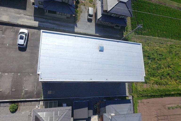 <p>今回の工事では、屋上・玄関上防水ともに15MPa以上の高圧洗浄を実施し、防水面の汚れや劣化物を除去した後、浮き・ひび割れなどの下地補修を行いました。<br>

その後、既存シート防水を活かしたままルーフガードNTゴムによるトップコートを施工し、平場・立上りまで丁寧に仕上げることで、防水性能と耐候性を回復しました。また、ドレン部の補修も実施し、排水機能の向上と雨漏りリスクの低減を図っています。<br>

昇降階段や親綱柱・親綱設置など安全対策も徹底し、安全性を確保しながら高品質な防水改修工事を行いました。<br>

使用材料・施工内容<br>

屋上防水工事<br>

* 高圧洗浄（15MPa以上）<br>
* 下地補修<br>
* ルーフガードNTゴム<br>
* 平場トップコート施工<br>
* 立上りトップコート施工<br>
* ドレン補修<br>

玄関上防水工事<br>

* 高圧洗浄（15MPa以上）<br>
* 下地補修<br>
* ルーフガードNTゴム<br>
* 平場トップコート施工<br>
* 立上りトップコート施工<br>
* ドレン補修<br>

仮設工事<br>

* 昇降階段設置<br>
* 親綱柱設置・撤去<br>
* 親綱設置・撤去<br>

建物診断<br>

* ドローン無料調査<br>
* 横井豊文教師建物診断</p><p><br></p>
