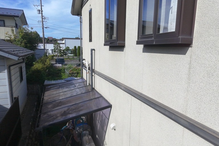 <p>長野県上伊那郡飯島町にて、ドローンを活用した建物診断を実施しました。<br>

今回の調査では、通常では確認しにくい屋根をドローンで上空から撮影するとともに、外壁や付帯部についても建物全体の状態を確認しました。<br>

屋根は太陽光パネルが設置されているため、パネル周辺や谷部、雨水が集まりやすい箇所などを重点的に確認。屋根材には経年による色褪せや汚れが見られ、軒先・雨樋周辺にも汚れの蓄積が確認できました。<br>

外壁では、特に建物下部や日当たり・風通しの影響を受けやすい場所に苔・藻・黒ずみなどの付着が見られました。こうした汚れは美観だけでなく、外壁の防水性能が低下しているサインとなる場合もあります。<br>

株式会社横井では、ドローン無料調査・横井豊史教師建物診断を活用し、目視だけでは確認しにくい部分までチェックしています。</p><p><br></p>
