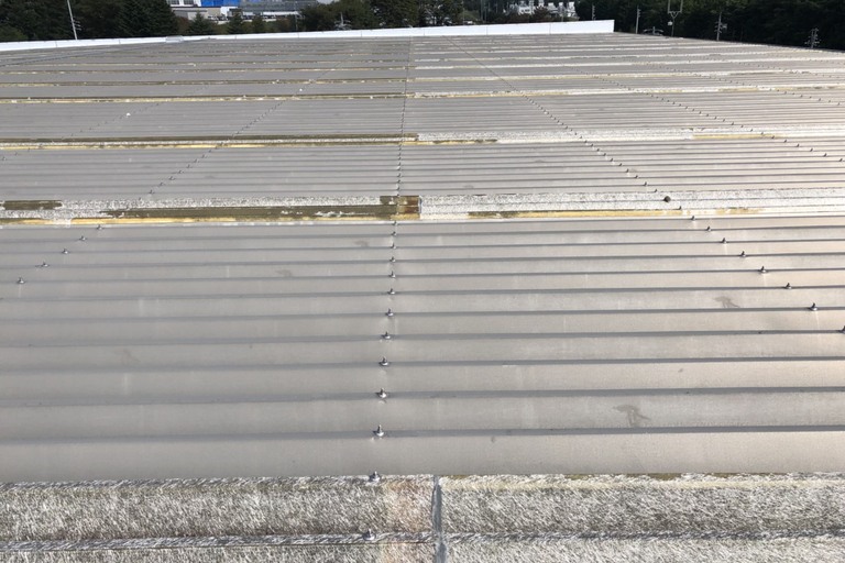 <p>長野県伊那市にて、工場のFRP折板屋根における重なり部分の防水工事をご依頼いただきました。<br>

工場などの大型建物に使用される折板屋根は、屋根材同士の継ぎ目や重なり部分が多く、経年劣化によって防水性能が低下すると雨水が浸入する原因となります。特にFRP折板屋根の重なり部分は、紫外線や雨風、温度変化による伸縮などの影響を受けるため、定期的な点検と防水処理が重要です。<br>

今回の現地確認では、明り取り部分を含めた屋根の重なり箇所を確認し、雨水の浸入を防ぐため、合計68ヶ所のFRP防水施工を行う計画としました。</p><p><br></p>