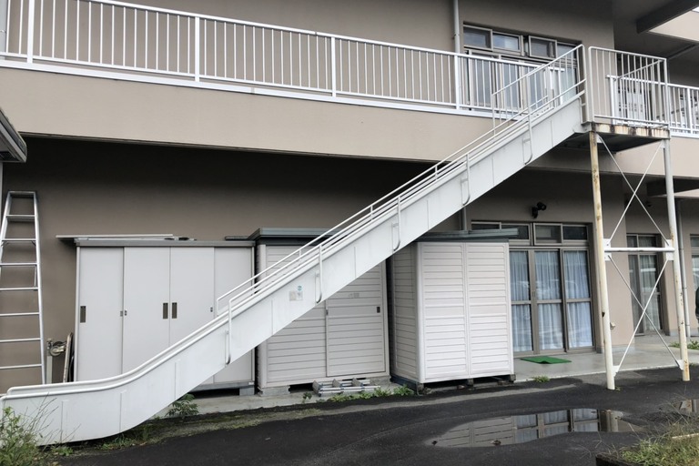 <p>長野県飯田市龍江の「ゆいの里」様にて、非常滑り台の手摺柱・床などの鉄部塗装工事をご依頼いただきました。<br>

現地調査では、屋外に設置されている鉄部に雨風や紫外線による塗膜の劣化が見られ、一部では腐食の進行も確認されました。鉄部は塗膜が劣化すると水分の影響を直接受けやすくなり、錆や腐食が広がることで耐久性の低下につながるため、適切な下地処理と防錆塗装が重要です。<br>

今回は約31㎡を対象に、高圧洗浄・腐食部分の下地処理・錆止め塗装を行ったうえで、耐久性を考慮した塗装仕上げをご提案しました。<br>

＊ドローン無料調査<br>
＊横井豊史教師建物診断</p><p><br></p>