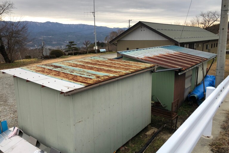 <p>長野県下伊那郡松川町にある「増野自治会 会所」にて、波トタン屋根の塗装工事を行いました。<br>

波トタン屋根は屋外で雨風や紫外線を受け続けるため、年月の経過とともに塗膜が劣化し、色あせや保護性能の低下が起こります。さらに劣化が進むと、金属部分に錆や腐食が発生する可能性があるため、屋根材を長持ちさせるには適切な防錆塗装が欠かせません。<br>

今回の施工対象は約15㎡。高圧洗浄による下地づくりから始め、錆止め、中塗り、上塗りと順に塗膜を形成する仕様で施工しました。<br>

＊ドローン無料調査<br>
＊横井豊史教師建物診断</p><p><br></p>