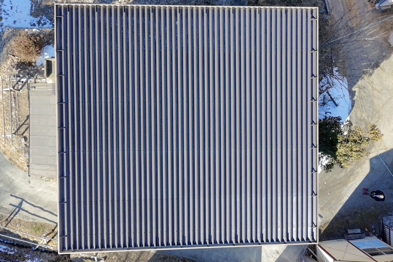 <p>施工では、屋根約141㎡を高圧洗浄し、長年蓄積した汚れや劣化塗膜を丁寧に除去した後、塗装工事を行いました。</p><p>下塗りには防錆性に優れたCCP-177を使用し、鉄部をしっかり保護。その後、遮熱塗料タフコートD-42による中塗り・上塗りを施工しました。遮熱性能と耐候性を兼ね備えた塗膜を形成することで、屋根の温度上昇を抑えながら、紫外線や雨風から建物を長期間保護できる仕上がりとなりました。<br>

また、安全性に配慮しながら梯子作業による施工を実施し、細部まで丁寧に仕上げることで、美観と耐久性を兼ね備えた屋根へと生まれ変わりました。<br>

使用材料・施工内容<br>

屋根塗装工事<br>

* 高圧洗浄<br>
* 下塗り：CCP-177<br>
* 中塗り・上塗り：タフコートD-42（遮熱塗料）<br>

仮設工事<br>

* 梯子作業<br>

建物診断<br>

* ドローン無料調査<br>
* 横井豊史教師建物診断</p>