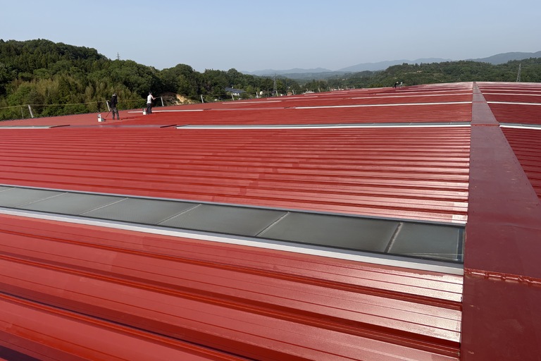 <p>11,617㎡におよぶアマダ福島工場様の超大規模屋根塗装工事が、細部まで徹底的に美しく完了いたしました！<br>

広大な屋根全面に強力な高圧洗浄を施した後、下塗りには金属部のサビをガッチリ防ぎ、塗膜を強固に密着させる防錆下地材「スーパーボウセイエポ」を全面に塗布。中塗り・上塗りには、極めて高い耐候性と美観維持力を誇り、工場内の温度上昇を抑える高級フッ素樹脂塗料「ルーフスターF」を採用し、3度塗りの高耐候仕様で仕上げました。<br>

これだけの広範囲でありながら、色ムラや隙間のない完璧な塗膜でコーティングされ、工場の省エネ・カーボンニュートラルへの貢献とともに、長期にわたって建物を守り続ける最高峰の仕上がりとなりました。</p><p><br></p>
