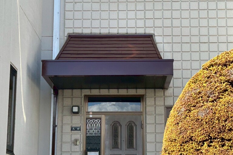 <p>今回の工事では、玄関上屋根を高圧洗浄で汚れを除去した後、コロニアル部分にはハイパーシーラーエポ、鉄部にはサビ止め塗料で下塗りを施工しました。<br>

その後、仕上げにはハイパーユメロックルーフを中塗り・上塗りの2回塗りで施工し、防水性・耐候性に優れた美しい屋根へと仕上げています。さらに、縦樋についてもハイパーユメロックルーフで塗装を行い、建物全体に統一感のある外観となりました。<br>

医院をご利用される患者様にも安心していただけるよう、安全管理を徹底しながら短期間で施工を完了しました。<br>

使用材料・施工内容<br>

屋根塗装<br>

* 高圧洗浄<br>
* ハイパーシーラーエポ下塗り（コロニアル）<br>
* サビ止め下塗り（鉄部）<br>
* ハイパーユメロックルーフ中塗り・上塗り<br>

付帯部塗装<br>

* 縦樋塗装（ハイパーユメロックルーフ）<br>

仮設工事<br>

* 脚立足場設置<br>
* 安全管理</p><p><br></p>