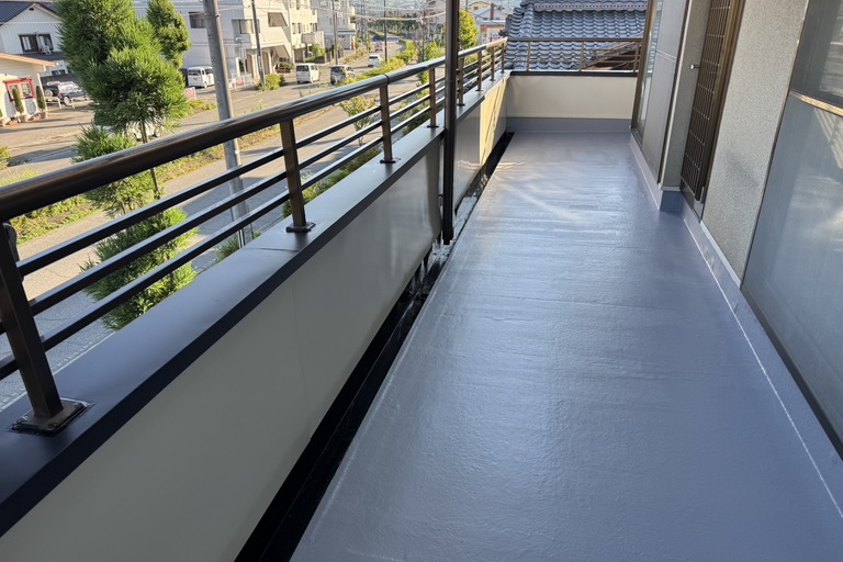 <p>今回の工事では、既存防水層を撤去した後、野地板や下地の補修・補強工事を実施し、新たにFRP防水を施工しました。耐久性・防水性に優れたFRP防水により、ベランダ全体の防水性能を大幅に向上させています。<br>

また、ベランダ内壁の鉄部には2液サビカットを下塗りし、仕上げにはユメロックを施工することで、防錆性能と美観を向上させました。さらに、笠木はGL鋼板による新設工事を行い、手摺の復旧やコーキング処理まで丁寧に施工することで、雨水の浸入を防ぎ、安心して長くお使いいただけるベランダへと生まれ変わりました。<br>

使用材料・施工内容<br>

ベランダ防水工事<br>

* 既存防水撤去<br>
* 野地板補修<br>
* 下地補強工事<br>
* FRP防水施工<br>

鉄部塗装<br>

* 2液サビカット下塗り<br>
* ユメロック中塗り・上塗り<br>

笠木改修工事<br>

* GL鋼板笠木新設<br>
* 笠木捨板施工<br>
* 笠木唐草施工<br>
* 手摺復旧<br>
* コーキング工事<br>

仮設工事<br>

* 昇降足場設置</p><p><br></p>